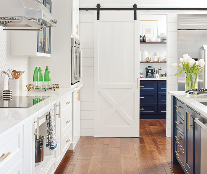 White kitchen cabinets with a custom blue kitchen island in the Renner door style